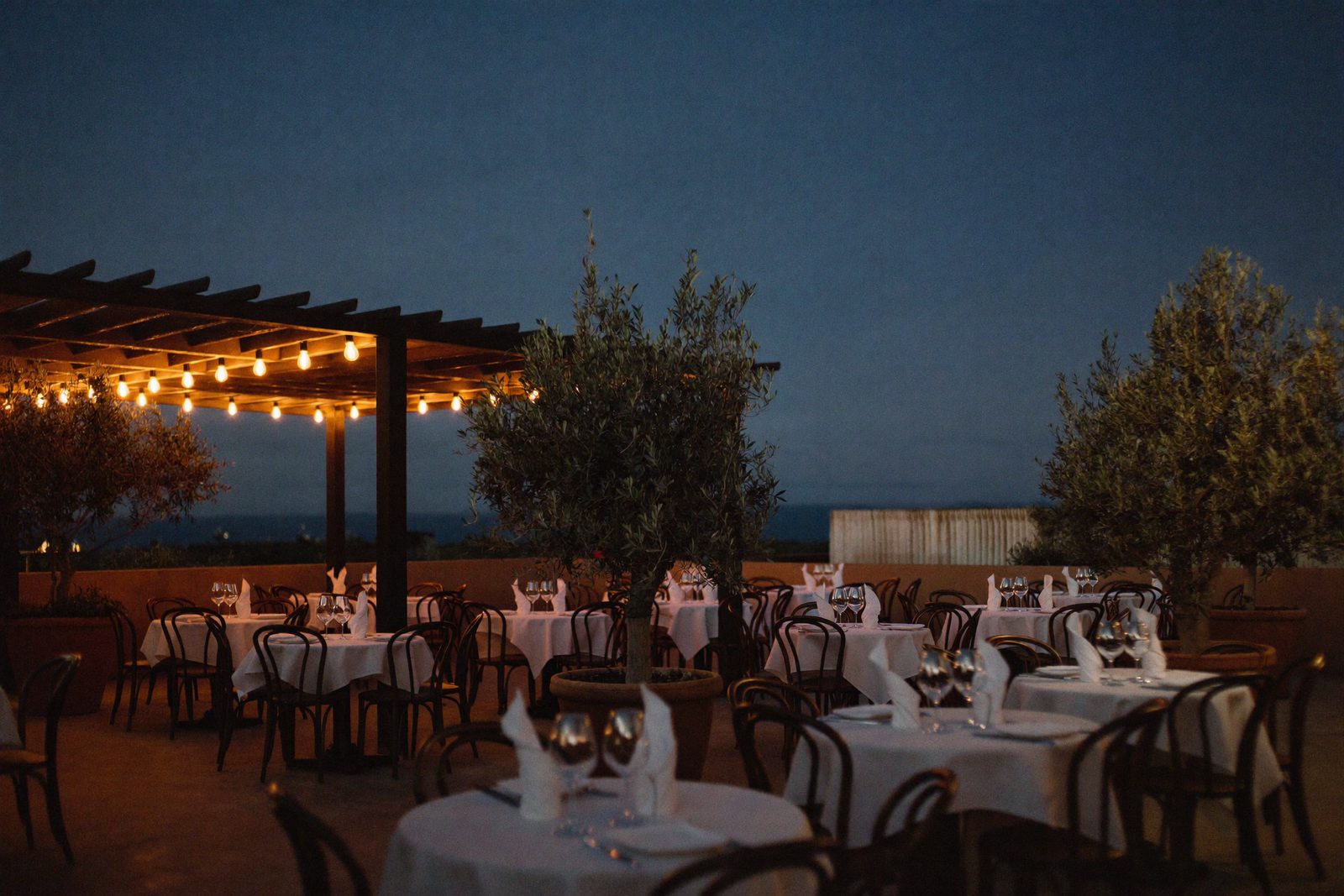 Restaurant terrace with guests seated at dusk